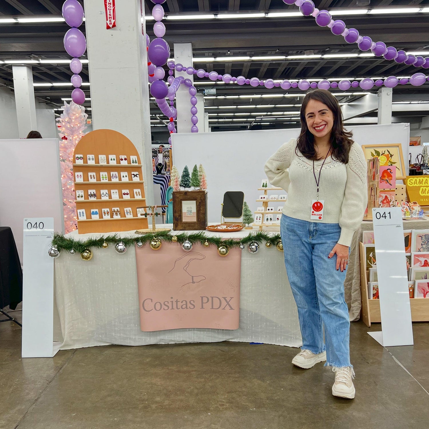 Lesly, Cositas PDX owner, standing at her market booth